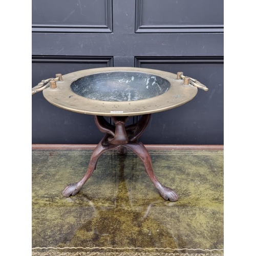 1071 - A brass twin handled bowl, diameter excluding handles 49.5cm, on ethnographic folding wood stan... 