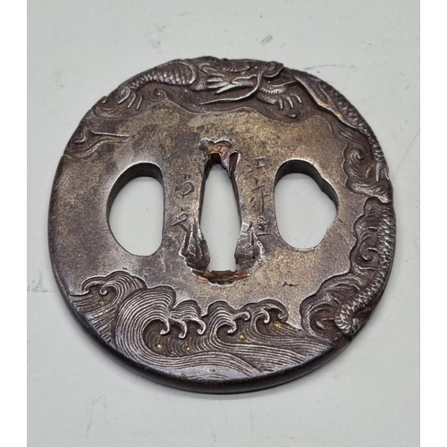 1586 - A Japanese cast iron tsuba, probably Edo, decorated with dragons and clouds, signed, 7 x 7.6cm.... 