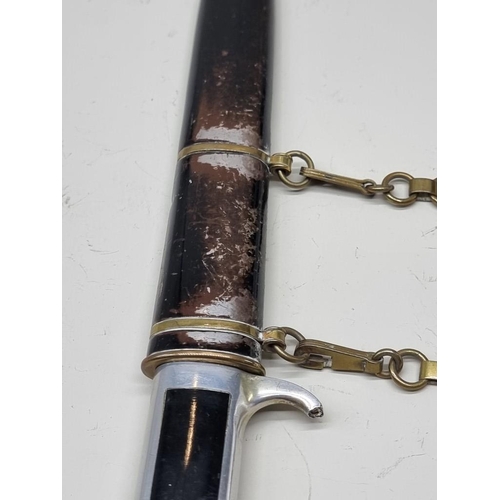 1665 - A World War II Italian model 1937 MVSN officer's dress dagger and scabbard, with brass hanger.... 