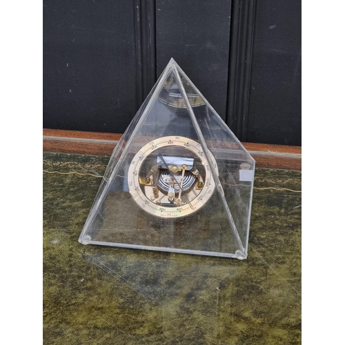 1391 - An aneroid barometer, in perspex pyramid case, 18cm high.