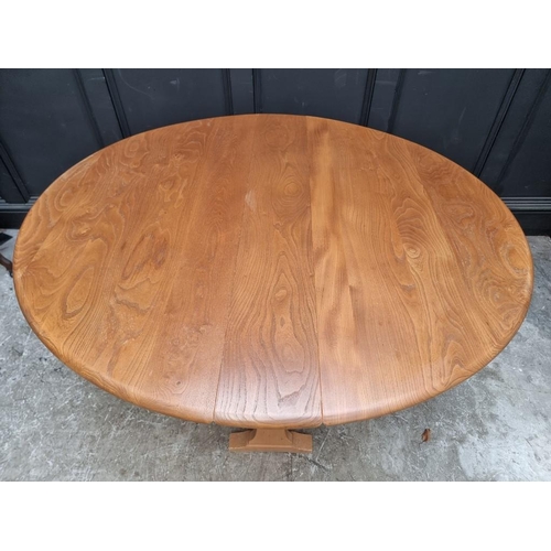 1005 - An Ercol elm drop leaf dining table, 139.5cm when open.