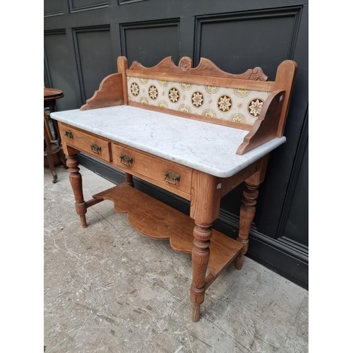 1007 - A late Victorian pine and marble top washstand, with tiled gallery back, 107cm wide.... 
