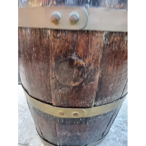 1031 - A coopered oak barrel stick stand, 61cm high.