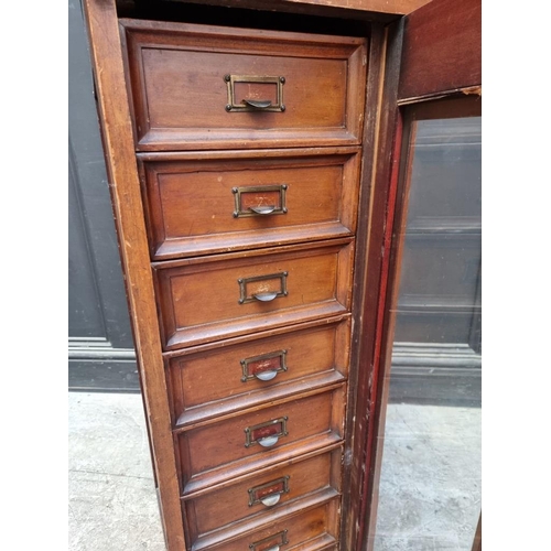 1057 - A vintage 'Su-Tall' mahogany haberdasher's chest, with a glazed panelled door enclosing eight small ... 
