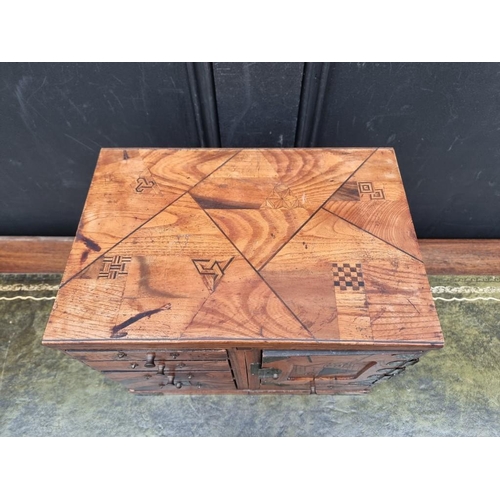 1059 - A Japanese parquetry table cabinet, 32cm wide, (formerly metamorphic).