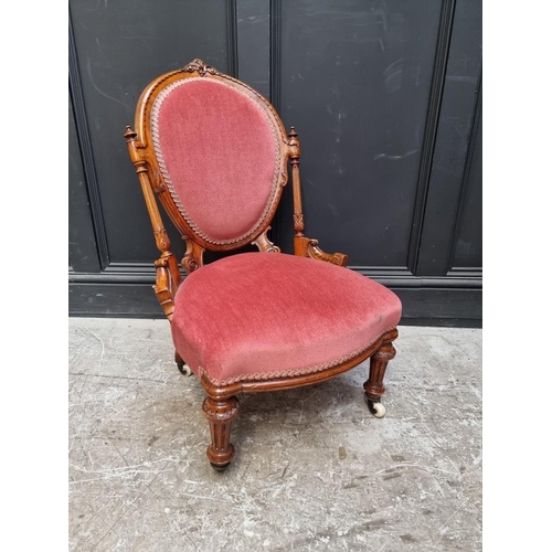 1072 - A Victorian carved walnut and upholstered nursing chair. 