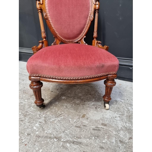 1072 - A Victorian carved walnut and upholstered nursing chair. 