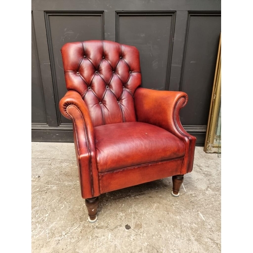 1073 - A reproduction buttoned red leather armchair, by Laura Ashley. ... 