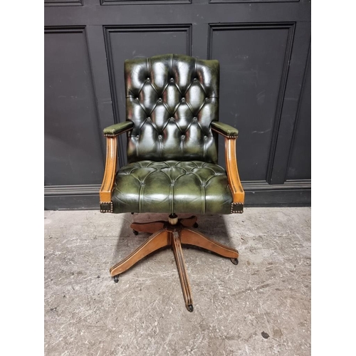 1074 - A buttoned green leather adjustable desk chair. 