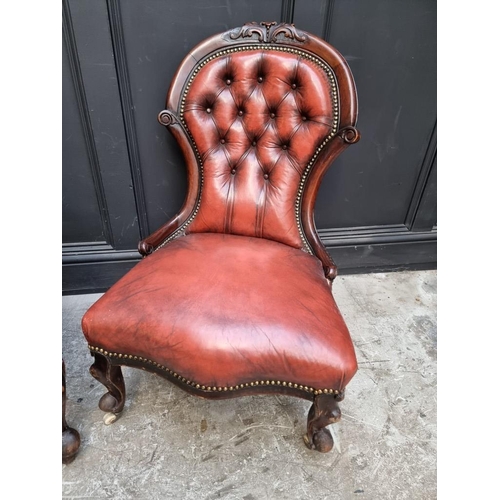 1076 - A pair of Victorian carved walnut and buttoned red leather occasional chairs. 