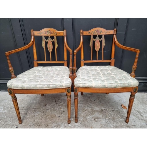 1077 - A pair of antique, Sheraton style, painted satinwood and cane open arm elbow chairs. ... 