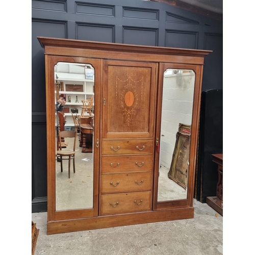 1093 - A late Edwardian mahogany and inlaid triple wardrobe, labelled 'Maple & Co', 190cm wide.... 