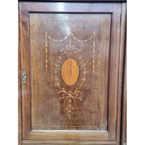 1093 - A late Edwardian mahogany and inlaid triple wardrobe, labelled 'Maple & Co', 190cm wide.... 