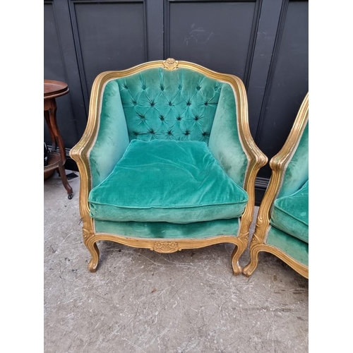 1098 - A large pair of Louis XV style giltwood and button upholstered fauteuils. 