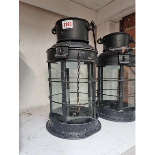 1193 - A pair of black painted hanging candle lanterns, largest 45cm high. (2)