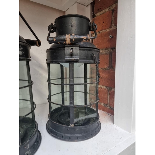 1193 - A pair of black painted hanging candle lanterns, largest 45cm high. (2)