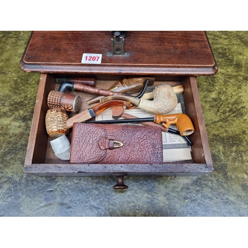 1207 - An antique mahogany smoker's companion, 33cm wide; with various pipes.