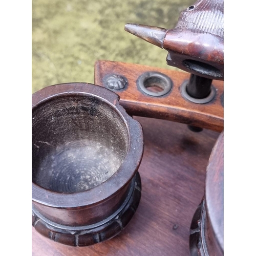 1207 - An antique mahogany smoker's companion, 33cm wide; with various pipes.