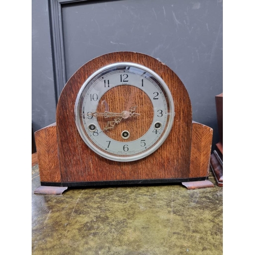 1225 - A 1930s mahogany and inlaid mantel clock, 29cm diameter; together with two further oak examples. (3)... 