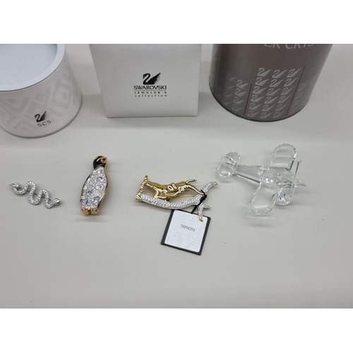 1238 - Three Swarovski brooches, two boxed, largest 6.5cm; together with another Swarovski aeroplane, boxed... 