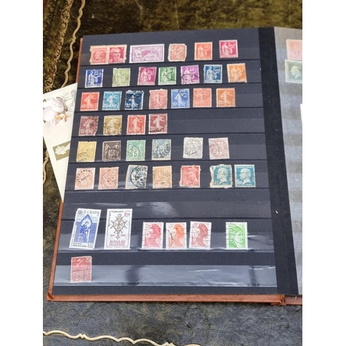 1313 - Stamps: a mixed world stock book; together with an early 20th century album of cigarette cards, to i... 