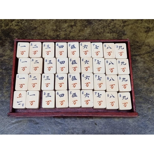 1322 - A Chinese hardwood cased bone and bamboo mahjong set. 