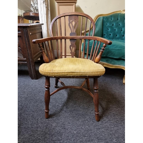 1070 - A 19th century yew and elm low back Windsor armchair, with crinoline stretcher, (slightly reduced in... 