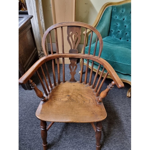 1070 - A 19th century yew and elm low back Windsor armchair, with crinoline stretcher, (slightly reduced in... 