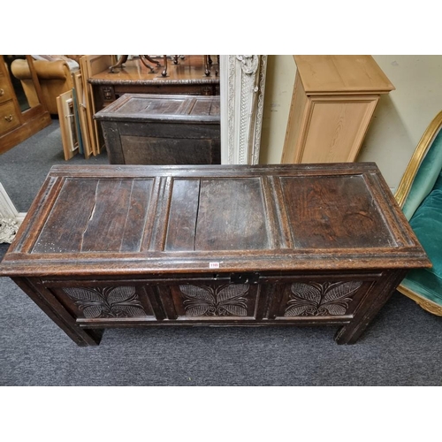 1105 - A late 17th century carved oak panelled coffer, 140cm wide.