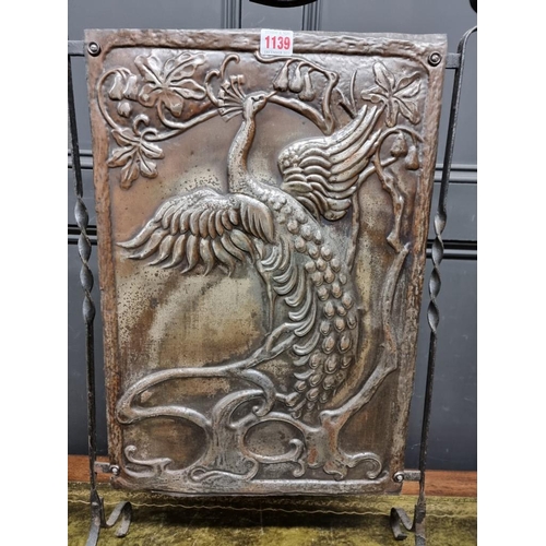 1139 - An Art Nouveau embossed metal fire screen, 50cm wide; together with a pair of brass andirons, 28.5cm... 