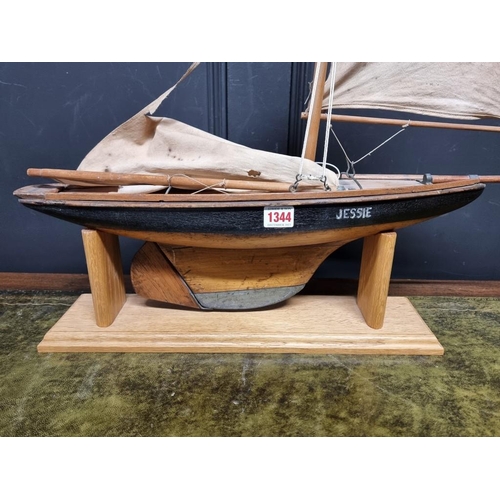 1344 - An old wood pond yacht, 63cm long, (sails distressed), on oak stand.