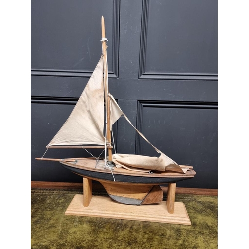 1344 - An old wood pond yacht, 63cm long, (sails distressed), on oak stand.