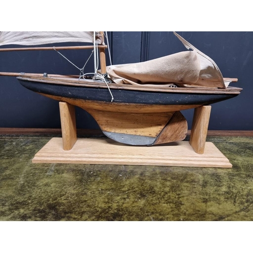 1344 - An old wood pond yacht, 63cm long, (sails distressed), on oak stand.