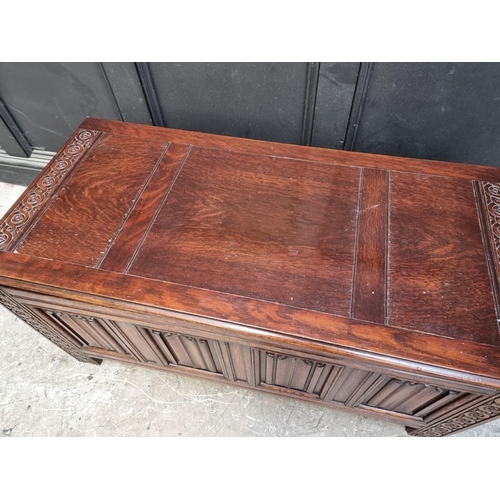 1127 - A reproduction oak linenfold coffer, 106.5cm wide.