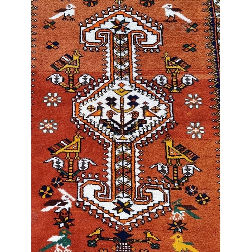 1353 - A Persian rug, with central geometric medallion, central field decorated with birds, borders have ge... 