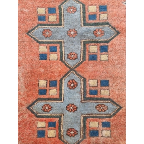 1355 - A Persian rug, having four geometric medallions, with geometric borders, 208 x 137cm.... 