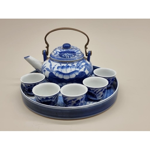 1470 - A Japanese blue and white sake set, the tray 26cm diameter. 