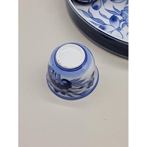 1470 - A Japanese blue and white sake set, the tray 26cm diameter. 