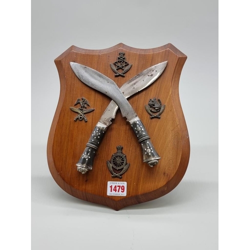 1479 - A Gurkha diorama, with two small kukris and related badges, on walnut easel back shield, 29cm high.... 