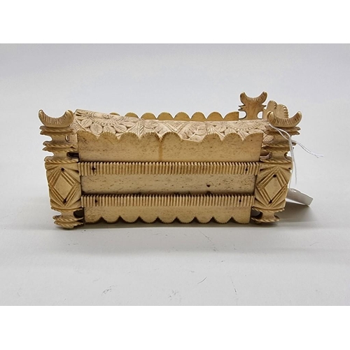 1533 - A Napoleonic prisoner-of-war carved bone sarcophagus form domino box, the inner cover of pierced cri... 