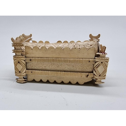 1533 - A Napoleonic prisoner-of-war carved bone sarcophagus form domino box, the inner cover of pierced cri... 