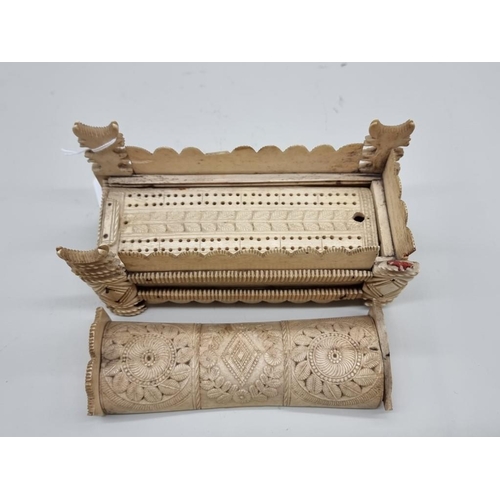 1533 - A Napoleonic prisoner-of-war carved bone sarcophagus form domino box, the inner cover of pierced cri... 