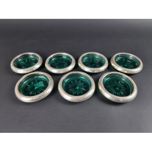 109 - Seven white metal mounted green glass ashtrays, stamped 'Crown Sterling'.