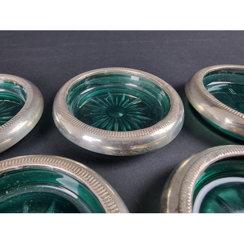 109 - Seven white metal mounted green glass ashtrays, stamped 'Crown Sterling'.