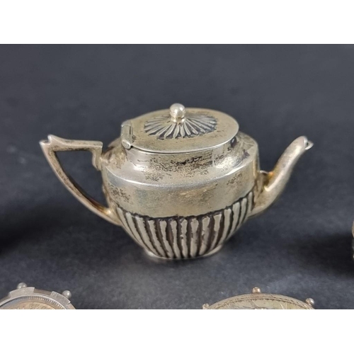 121 - A miniature white metal novelty teapot, stamped '925', 3.5cm high; together with a silver cycling br... 