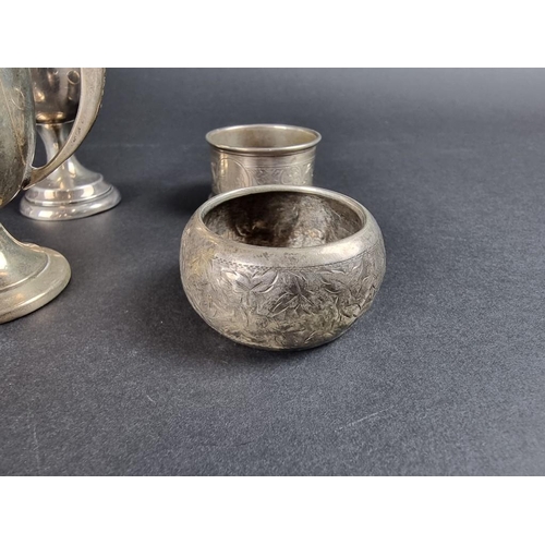 134 - A small group of silver, comprising two small twin handled trophy cups; a pair of silver napkin ring... 