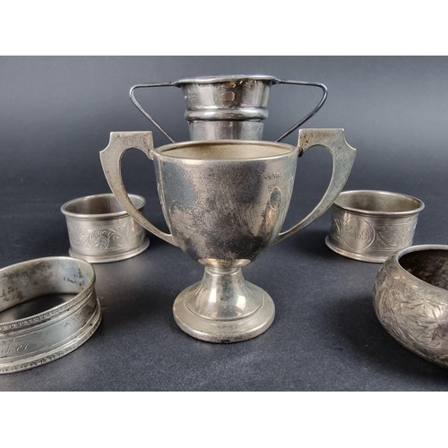 134 - A small group of silver, comprising two small twin handled trophy cups; a pair of silver napkin ring... 