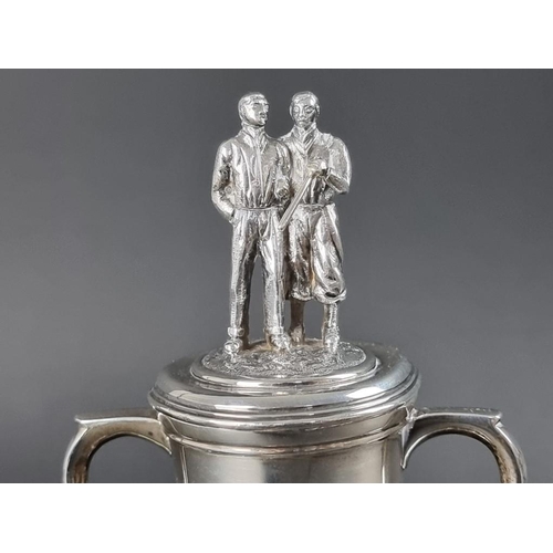 161 - A silver twin handled golfing trophy cup, having two male figures to lid, by Asprey & Co Ltd, Lo... 