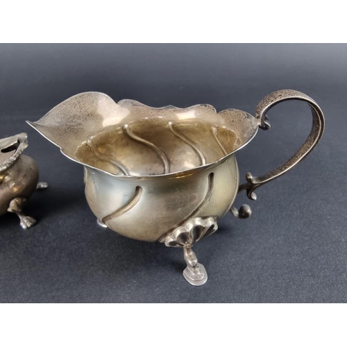 211 - An Edwardian silver cream jug, by Sibray, Hall & Co Ltd, London 1906, 17cm high; together with a... 