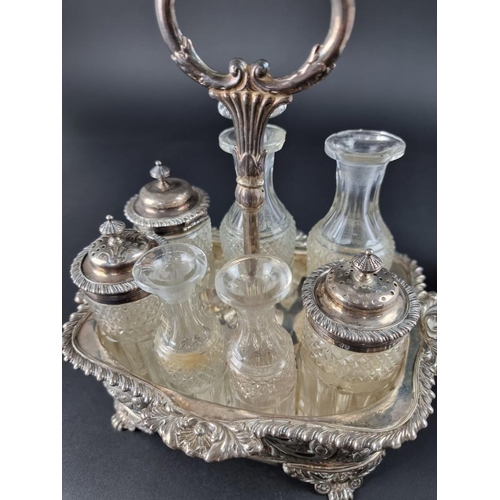 24 - A George IV silver cruet stand, with seven cut glass bottles, London 1823, 24cm high.... 